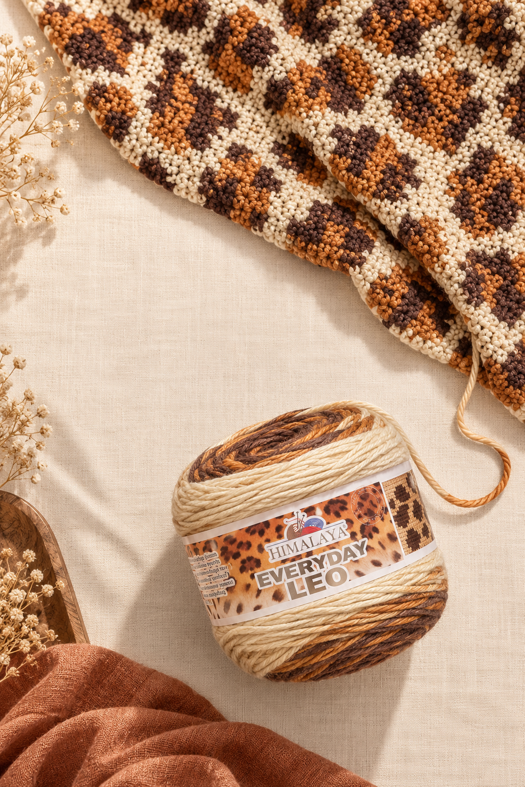 HiMALAYA Everyday Leo leopard-pattern yarn cake next to a crocheted leopard print blanket