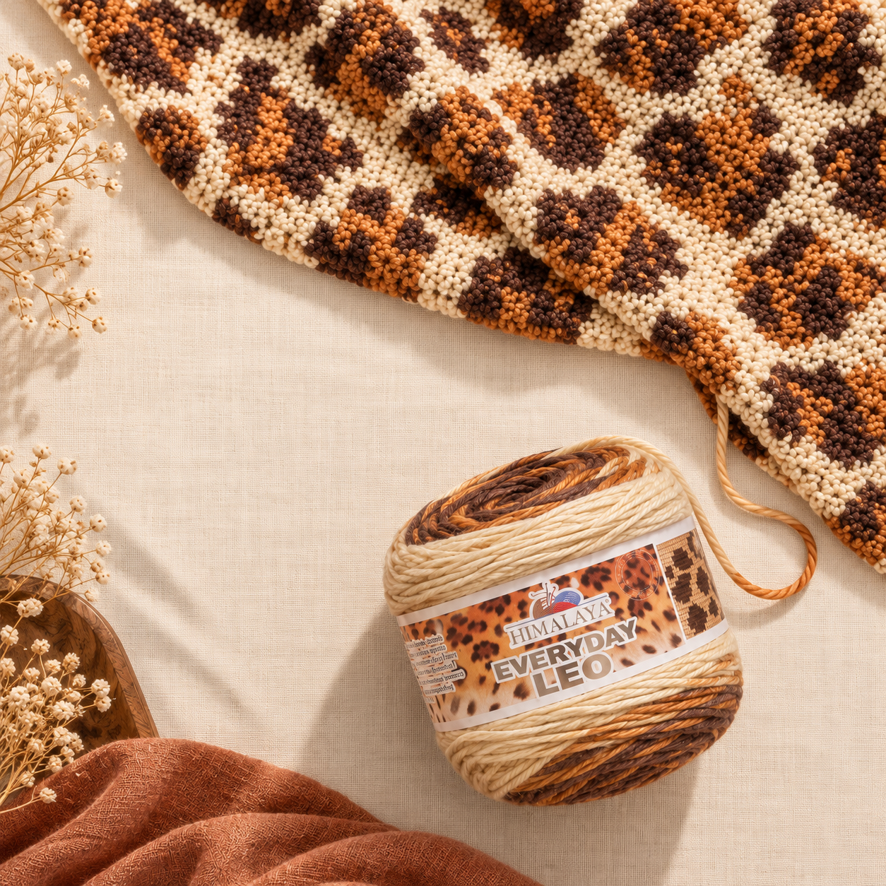 HiMALAYA Everyday Leo leopard-pattern yarn cake next to a crocheted leopard print blanket